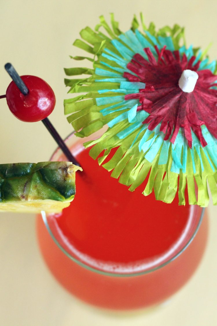 Overhead view of Zombie drink with pineapple and cherry with cocktail umbrella