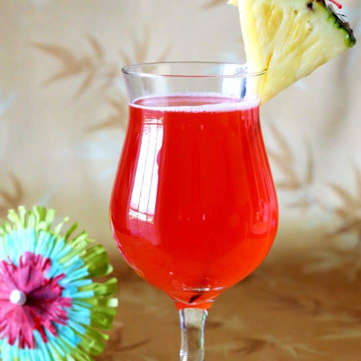 Zombie drink with pineapple and cherry against patterned backdrop